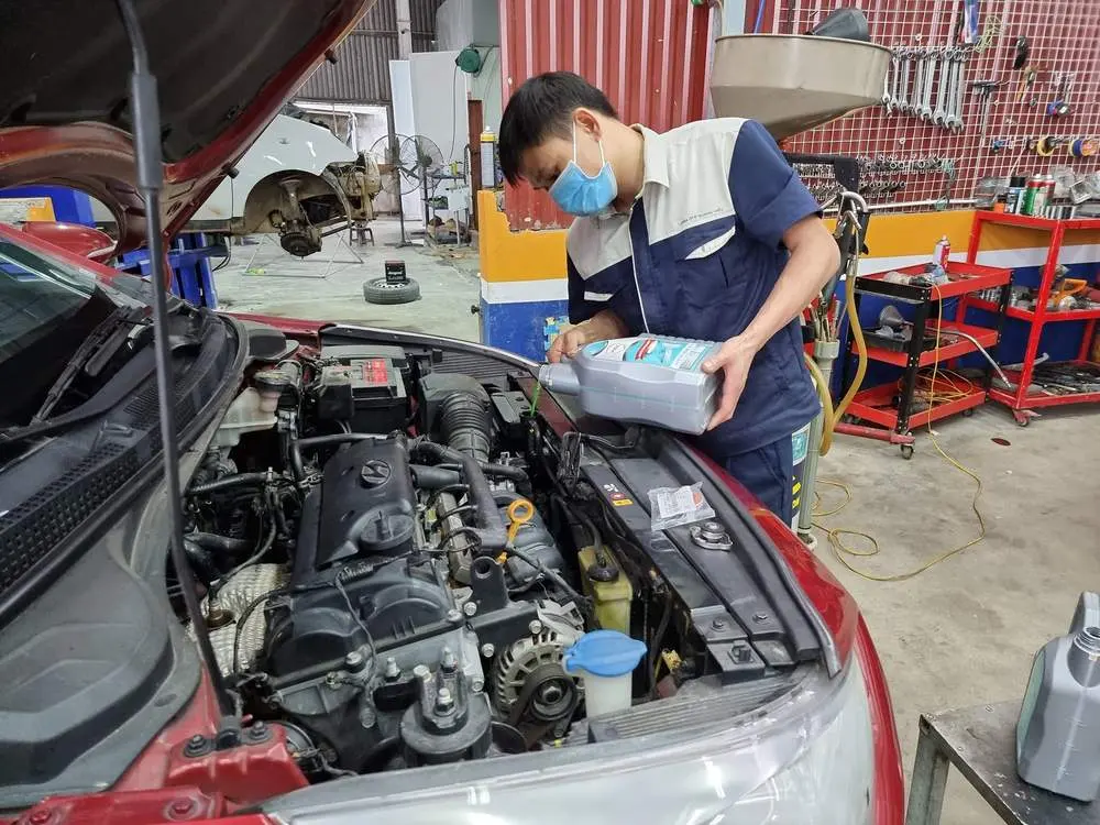 Một kỹ thuật viên tại Gara ô tô Quang Hiểu đang thay nước làm mát cho khách